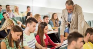 Professor helping student in lecture hall