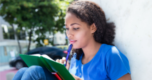 student reading outside campus building