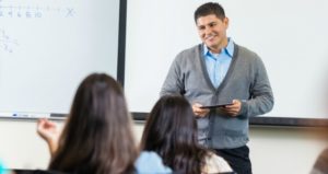 Male professor in front of room.