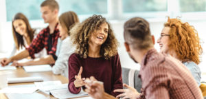 Students laughing while engaged in small group discussion—illustrating active learning