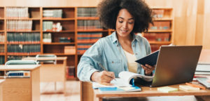 Young woman smiling as she studies in a library